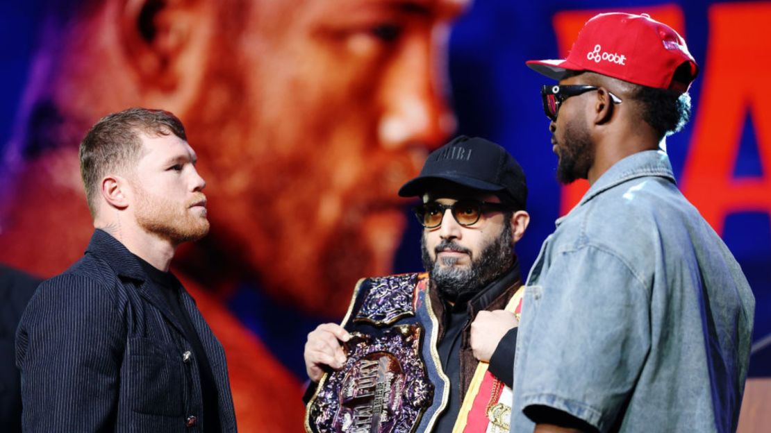 El mexicano Canelo Álvarez (a la izquierda) frente al cubano William Scull (a la derecha) mientras el presidente de la Autoridad General de Entretenimiento de Arabia Saudita, Turki Alalshikh (al centro), sostiene los cinturones durante una conferencia de prensa para promover su pelea por el Campeonato Mundial de Peso Supermediano, en el Radio City Music Hall, el 6 de marzo de 2025, en la ciudad de Nueva York.