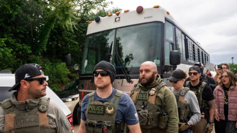 Agentes del Servicio de Inmigración y Control de Aduanas (ICE) caminan delante de un autobús en la oficina de campo del Departamento de Seguridad Nacional (DHS) en Nashville, donde múltiples grupos de defensa de los derechos de los inmigrantes se reunieron para protestar el 4 de mayo de 2025.