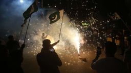 Pakistaníes ondean la bandera nacional mientras celebran después del alto el fuego entre Pakistán e India, en Hyderabad, provincia de Sindh, el 10 de mayo de 2025.