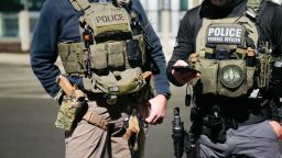 En esta foto facilitada por el ICE de EE.UU., dos agentes de las fuerzas federales de seguridad se coordinan con otros funcionarios sobre el terreno durante una operación reforzada de control de inmigración el 4 de febrero de 2025 cerca de la ciudad de Washington.