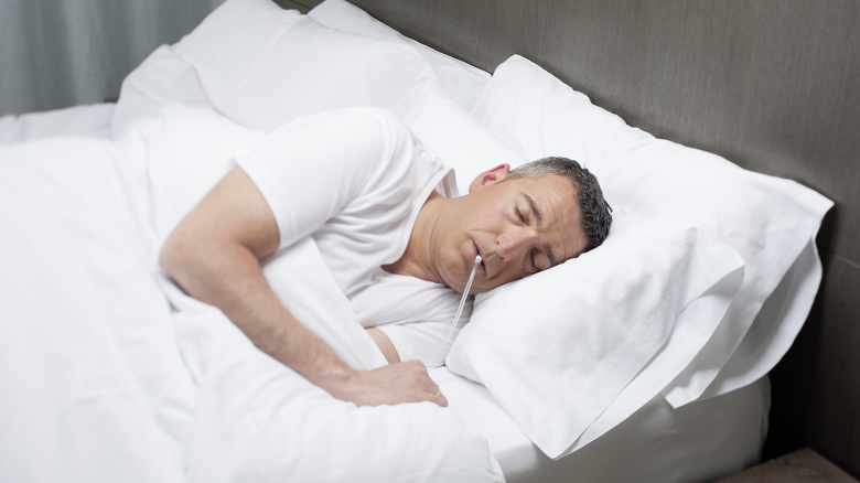 A man demonstrates the iNAP, a negative pressure device used for the treatment of obstructive sleep apnea.