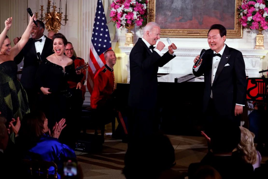 El presidente de EE.UU., Joe Biden, aplaude mientras el presidente de Corea del Sur, Yoon Suk Yeol, canta "American Pie" de Don McLean durante una cena de estado en la Casa Blanca, el 26 de abril de 2023 en Washington.