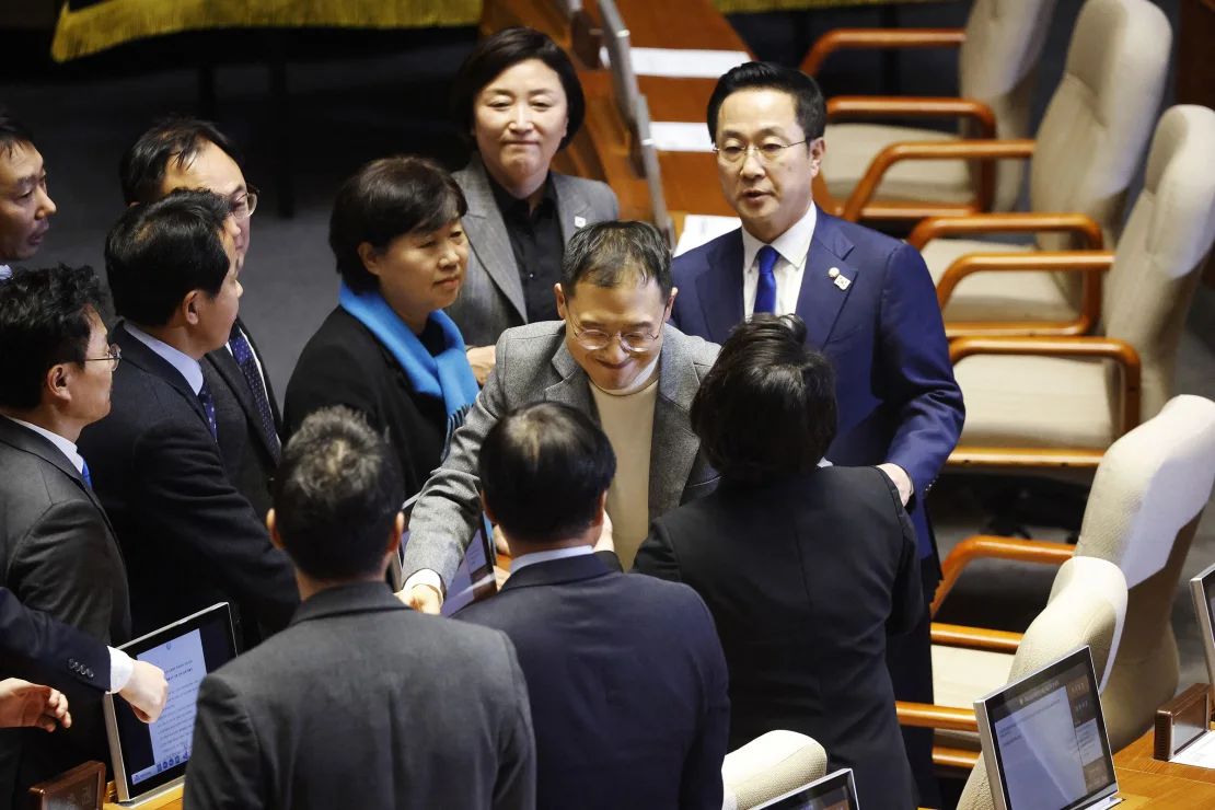 El legislador del Partido del Poder Popular, Kim Sang-wook, es recibido por miembros del partido de la oposición después de emitir su voto.