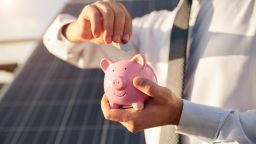 Putting money in your piggy bank to save for solar panels