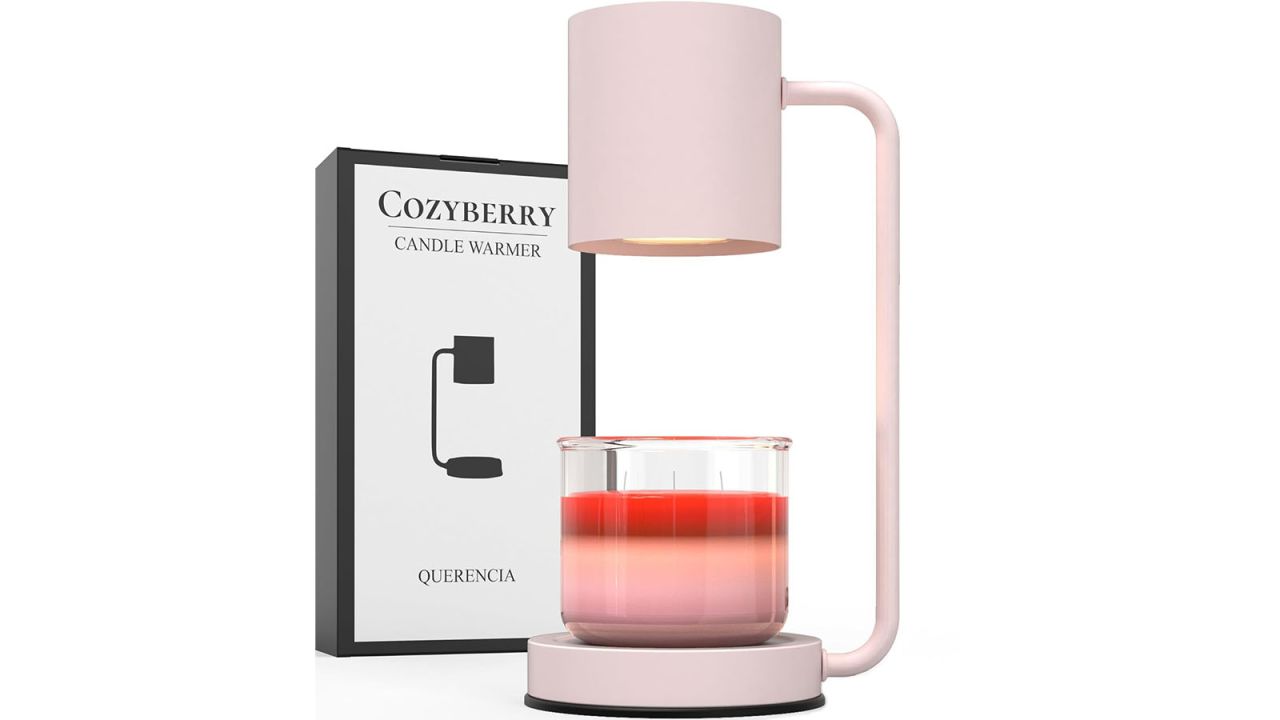 Pink candle warmer with small candle at base placed in front of product box.