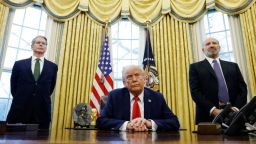 El secretario del Tesoro de EE. UU., Scott Bessent (izquierda), y Howard Lutnick (derecha), respaldan al presidente Donald Trump mientras este habla con la prensa en la Oficina Oval de la Casa Blanca el 3 de febrero en Washington, D. C.