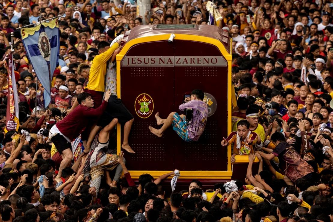 Devotos católicos filipinos se agolpan para tocar el carruaje que transporta la estatua del 'Nazareno negro' durante la procesión en Manila este jueves.