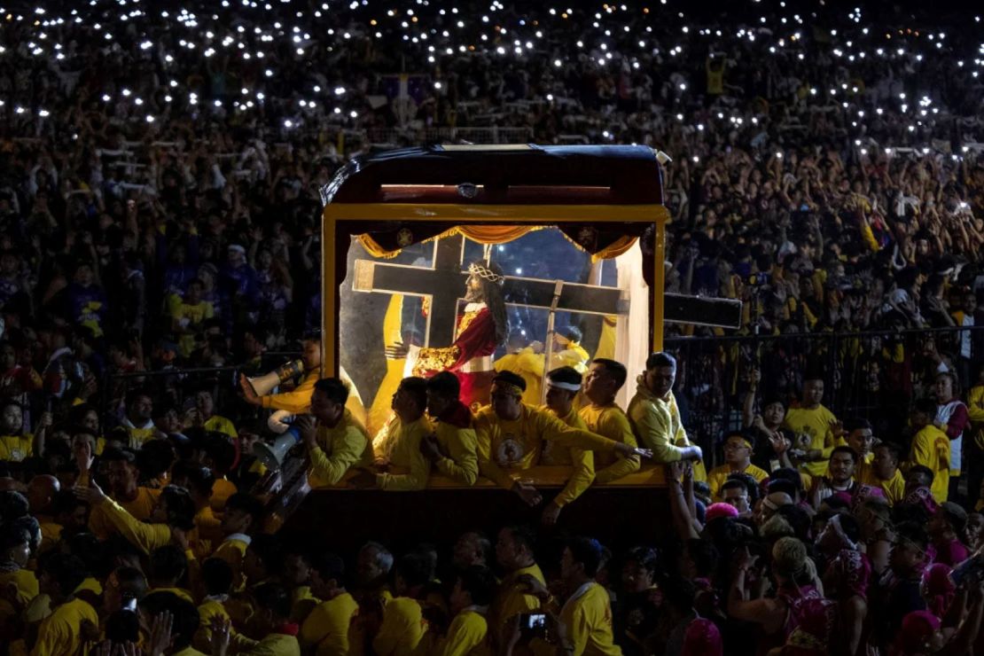 Devotos católicos filipinos rodean el carruaje que transporta la estatua del 'Nazareno negro' mientras comienza su procesión anual en su día festivo en Manila este jueves.