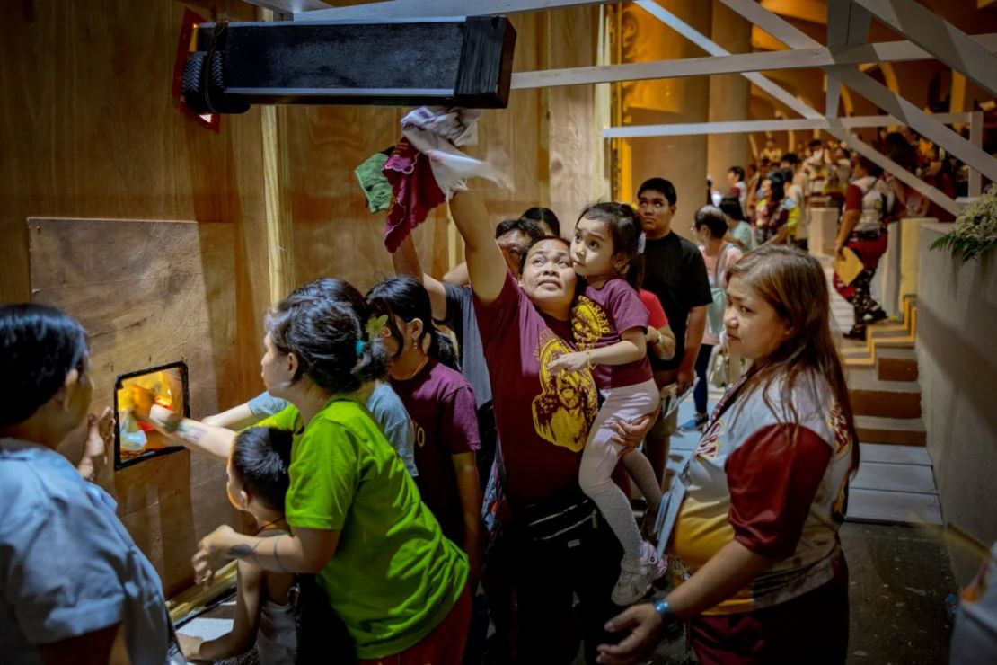 Devotos católicos hacen fila para tocar el 'Nazareno negro' antes de su procesión anual en Manila.