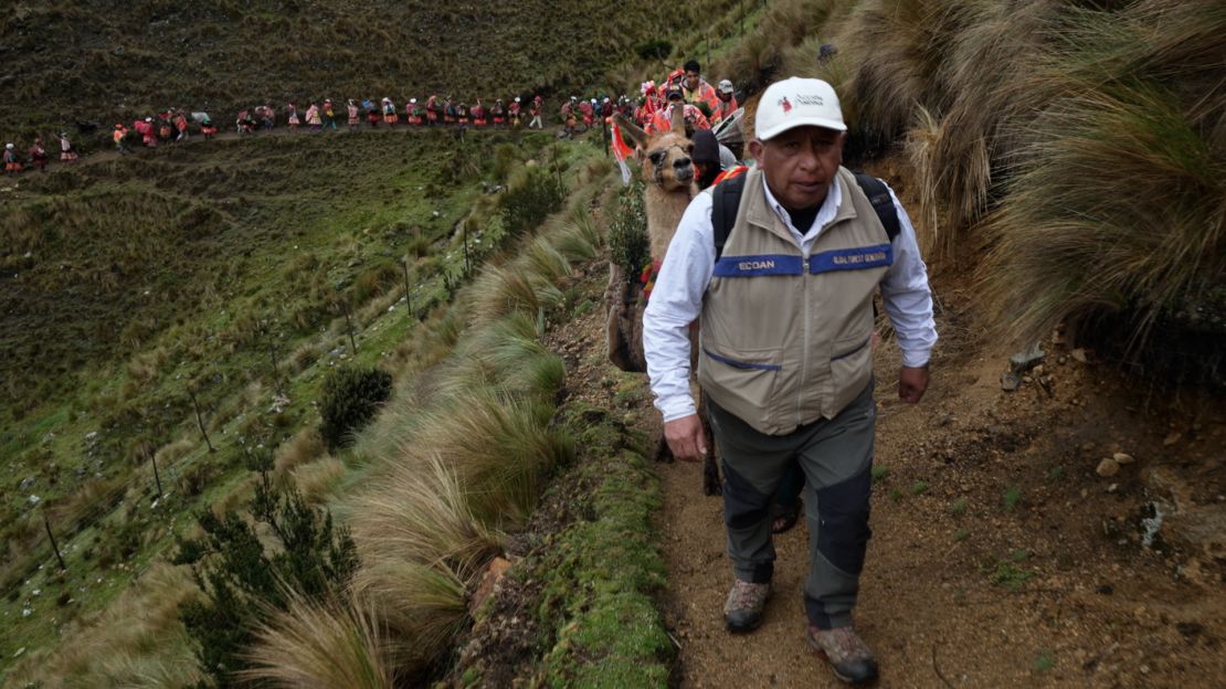 Constantino Aucca Chutas walks up a mountain with members of the local community to plant trees.