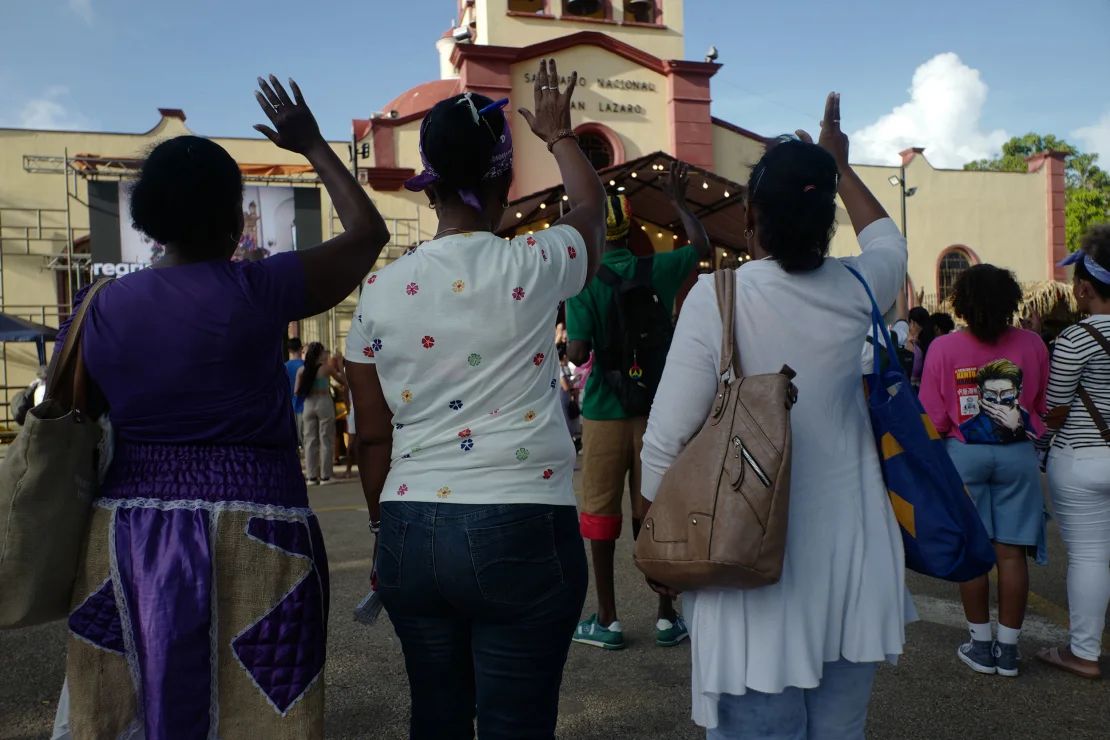 Mujeres participan en una misa al aire libre en la iglesia El Rincón. Tanto los católicos cubanos como los practicantes de la religión Santería participan en la peregrinación, una de las expresiones públicas de fe más significativas que ocurren en Cuba,