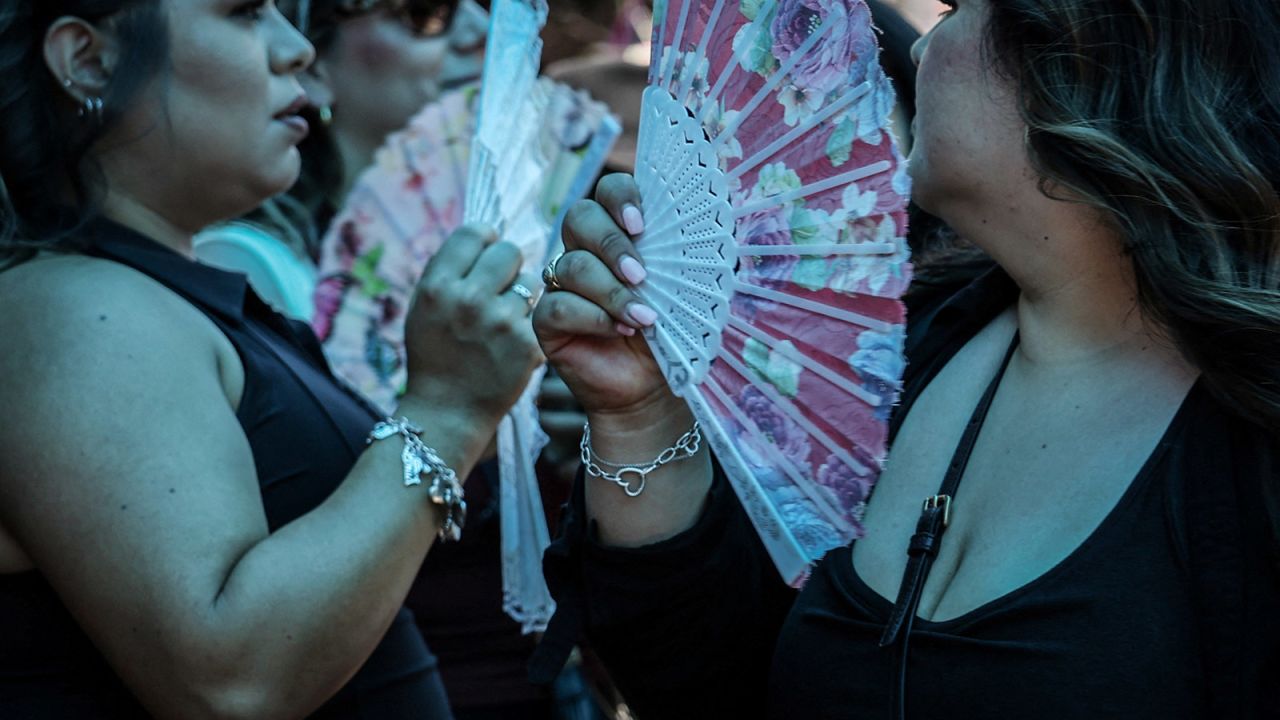 People buy fans in Chinatown during a heatwave affecting New York City on June 20. 