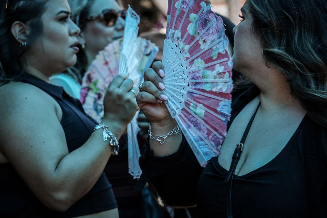 People buy fans in Chinatown during a heatwave affecting New York City on June 20. 