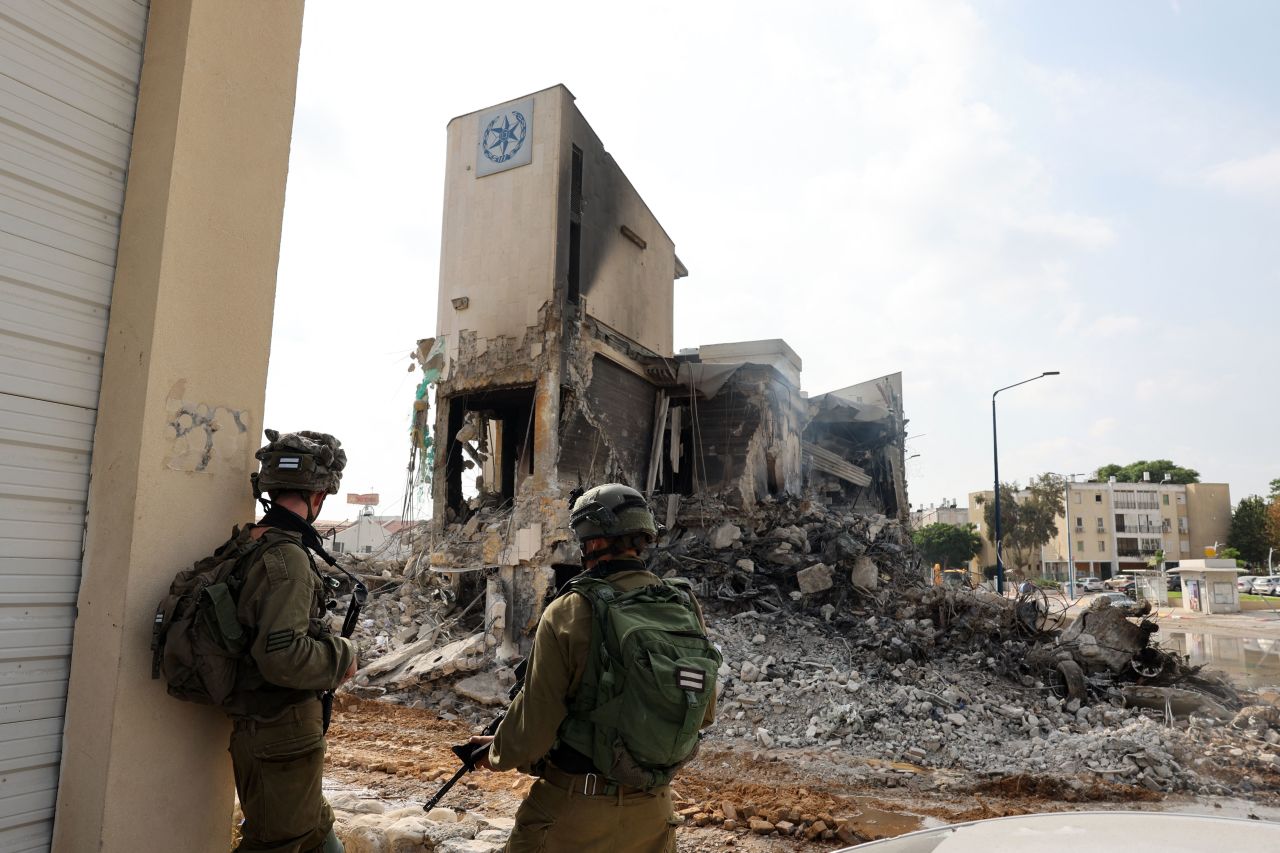 Soldiers stand in front of an Israeli police station that was damaged during battles to dislodge Hamas militants who were stationed inside, on October 8, 2023.