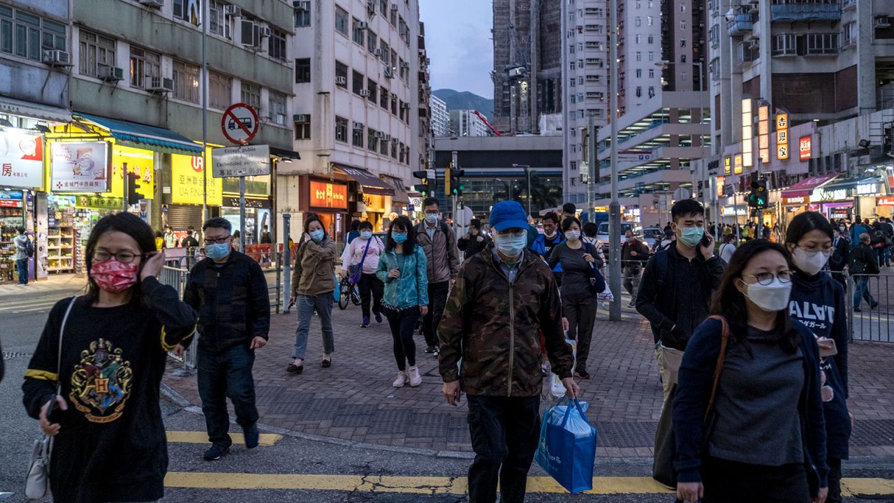 Pedestrians are seen wearing masks as they cross the street in Hong Kong on February 27.