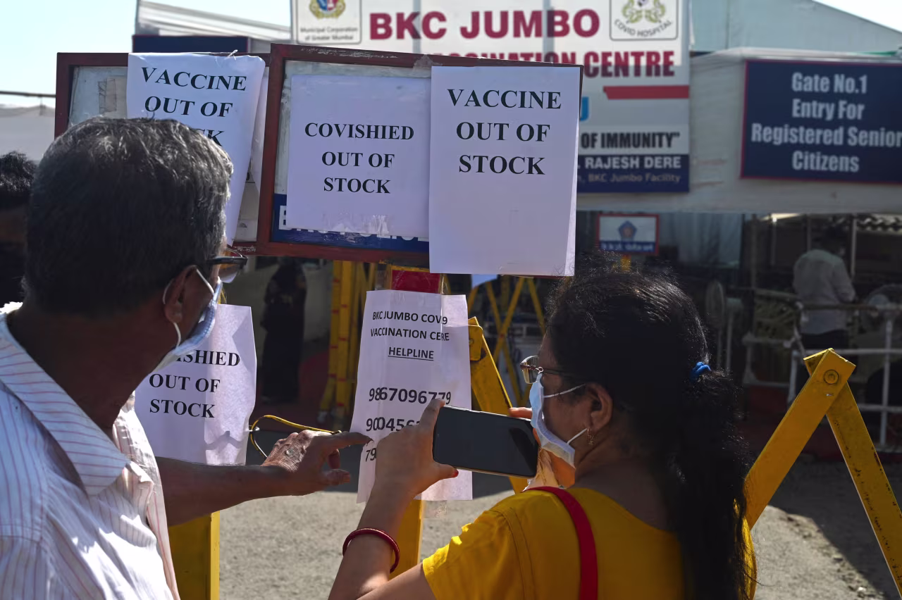 A person takes a photo of helpline numbers after Covishield Covid-19 vaccine went out of stock at a vaccination center in Mumbai on April 20.