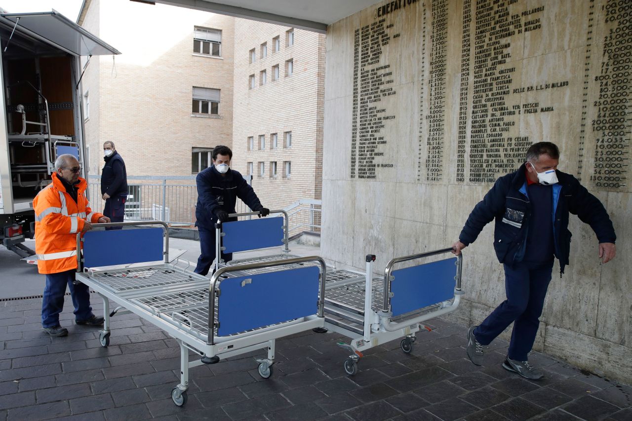 Hospital personnel in Codogno, Italy, carry new beds inside the hospital on Friday, February 21. The hospital is hosting some people who have been diagnosed with the novel coronavirus.