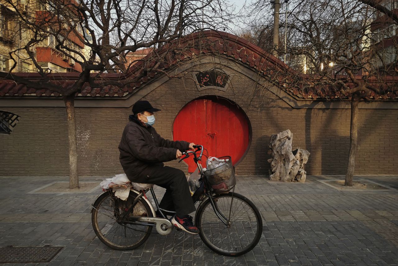 A Chinese man wears a protective mask as he rides his bike on February 23, 2020 in Beijing, China.