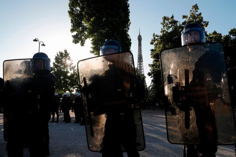 Riot policemen hold their shields with the Eiffel Tower in background during a protest at the Champ de Mars, in Paris on June 6.