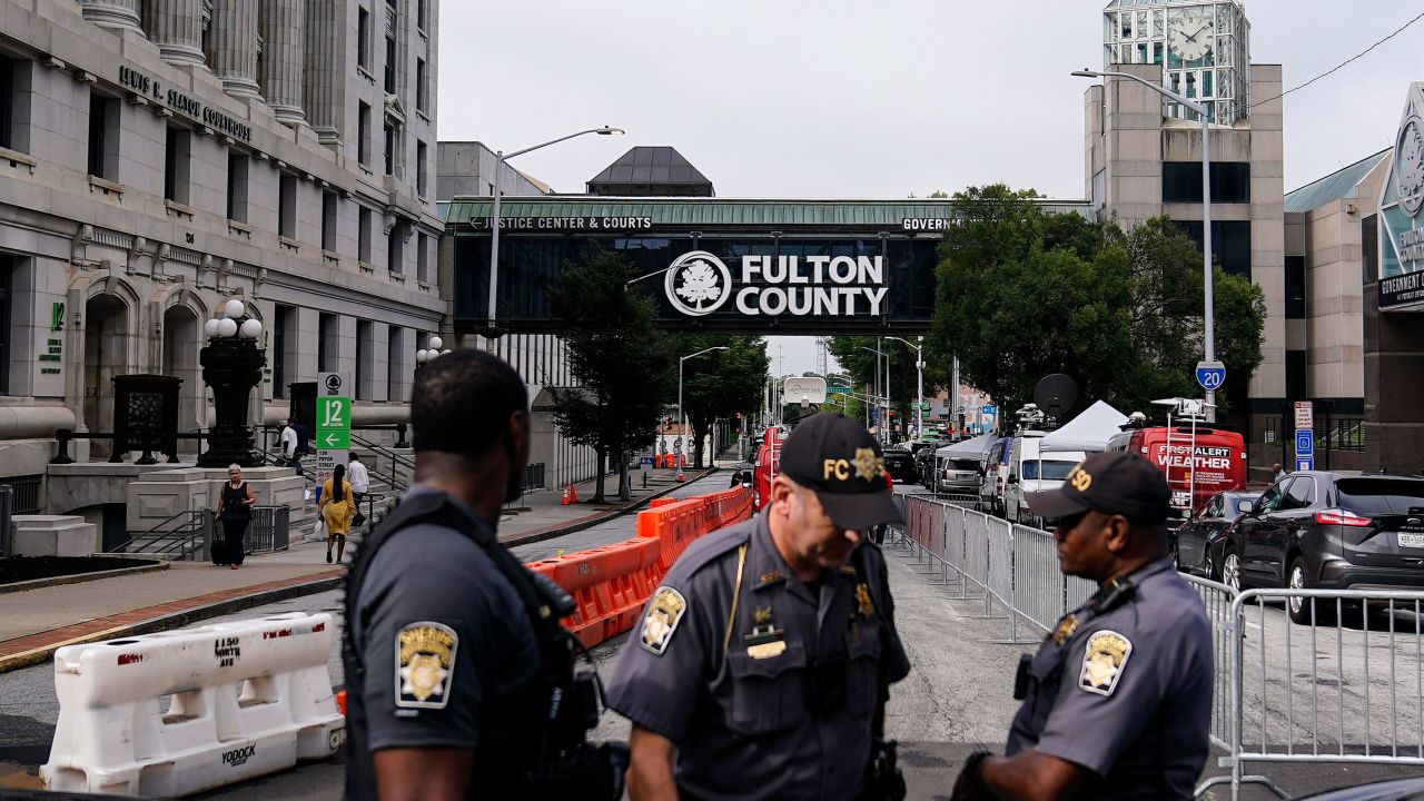 Authorities stand near barricades at the Fulton County courthouse, Monday, Aug. 7, 2023, in Atlanta. 