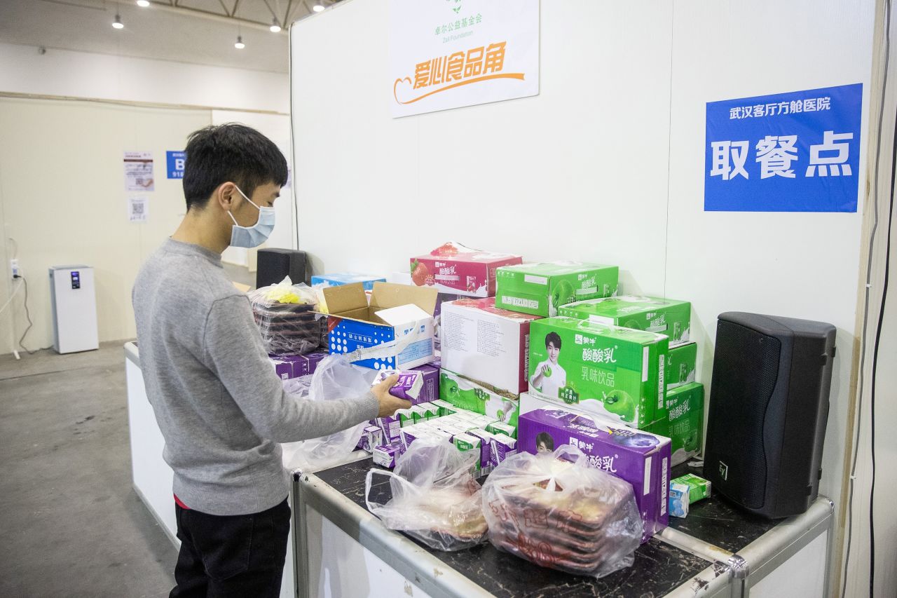 A patient helps himself to free drinks at the exhibition center-turned-hospital.