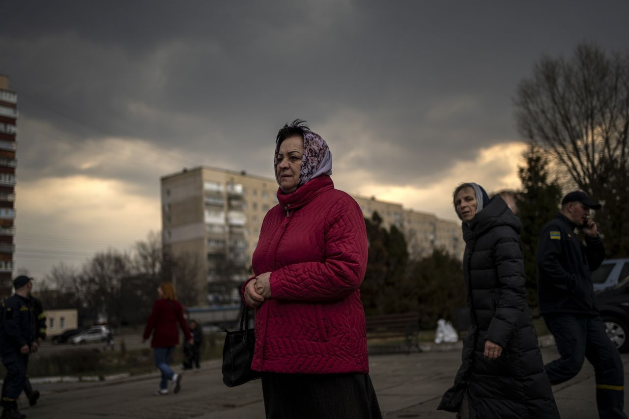 Residents watch a group of evacuated villagers arrive in Brovary, on the outskirts of Kyiv on March 29. The Ukrainian government evacuated the villagers due to heavy fighting against Russia. 