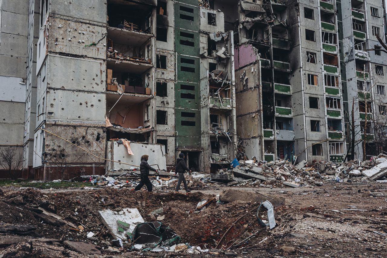 People walk in front of a destroyed building in Chernihiv on April 5.