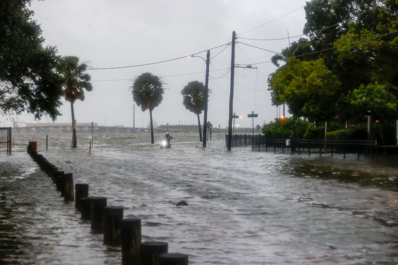 A man turns his motorcycle around on 26th Street as South Bermuda Boulevard is impassable in Tampa on Wednesday.