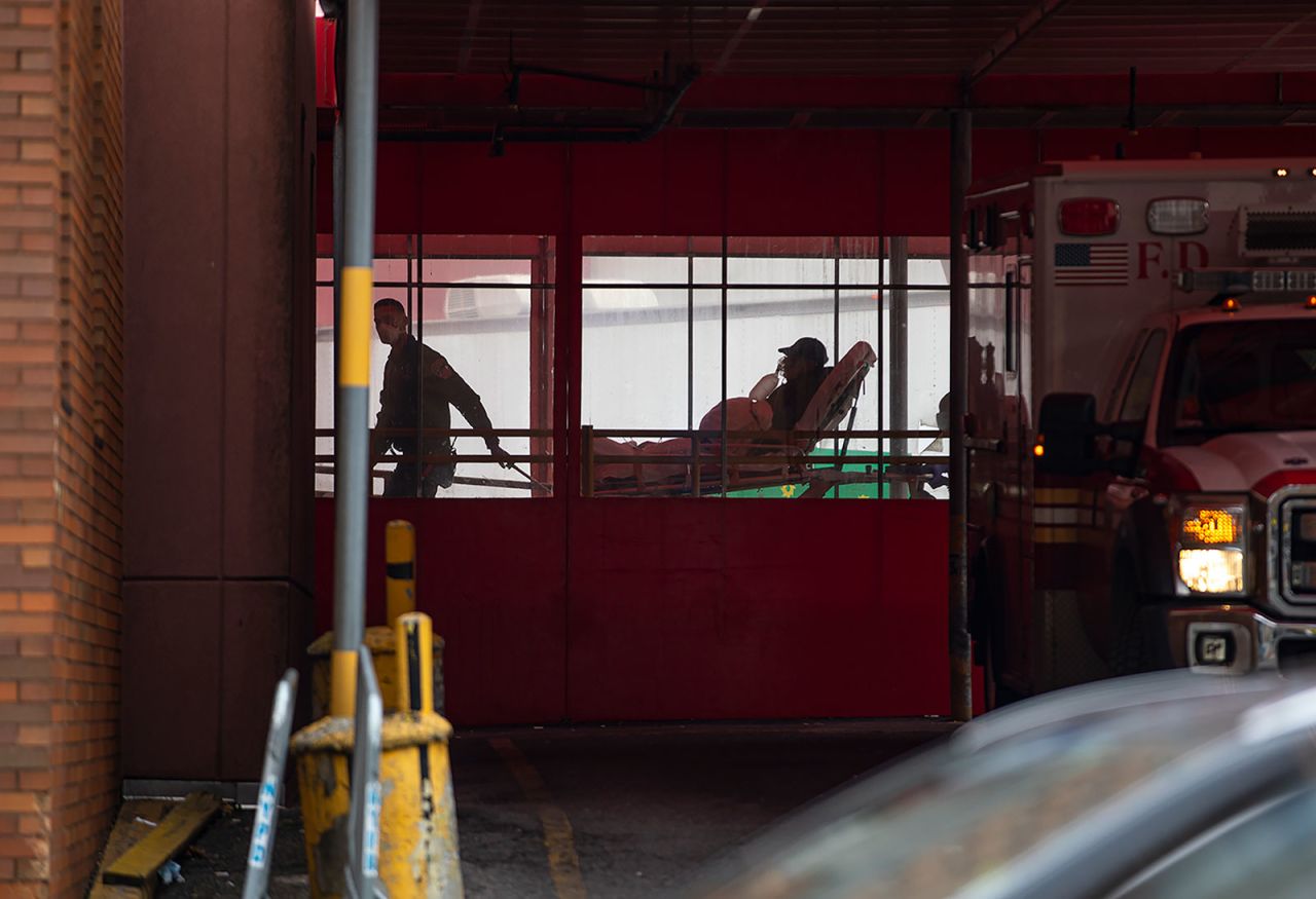 Two members of the New York City Fire Department's EMS team wheel a patient into Elmhurst Hospital Center in Queens, on March 30.