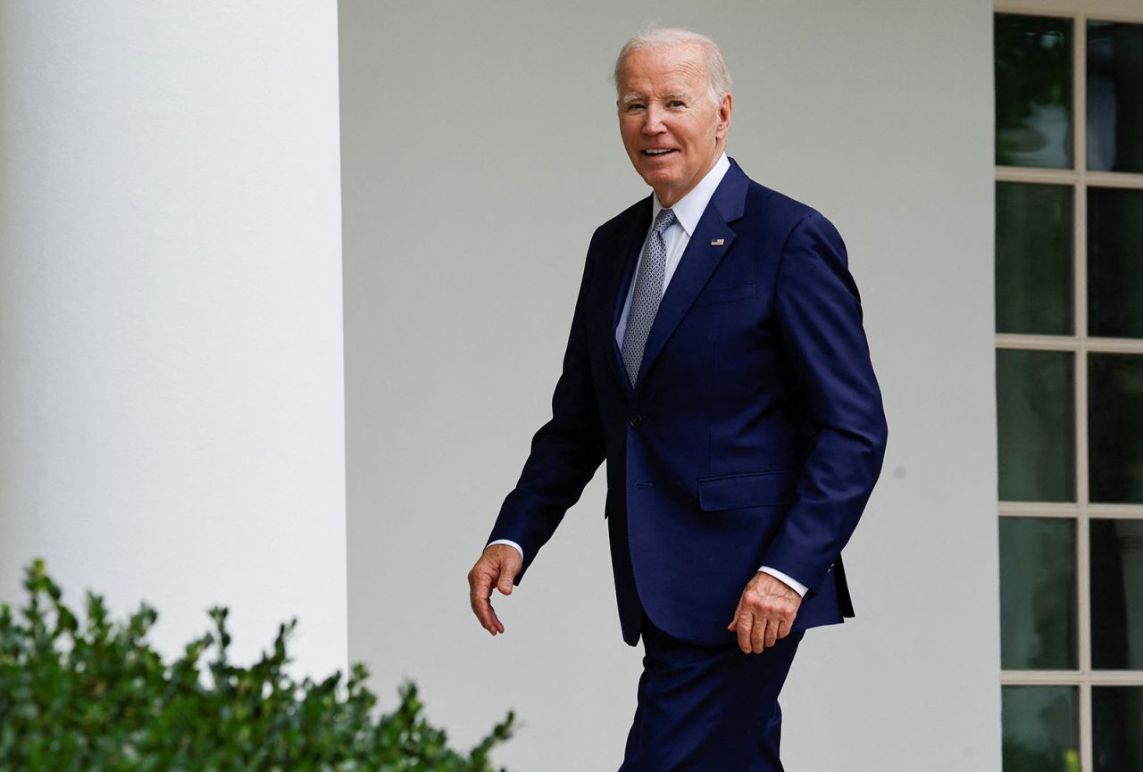 President Joe Biden smiles as he responds to a reporter's question about whether he will visit striking auto workers on the UAW picket line, as he walks back to the Oval Office of the White House in Washington on Friday. 