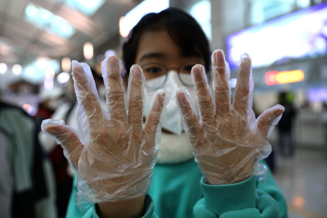A South Korean teenager wears plastic gloves at the Incheon International Airport, South Korea.?