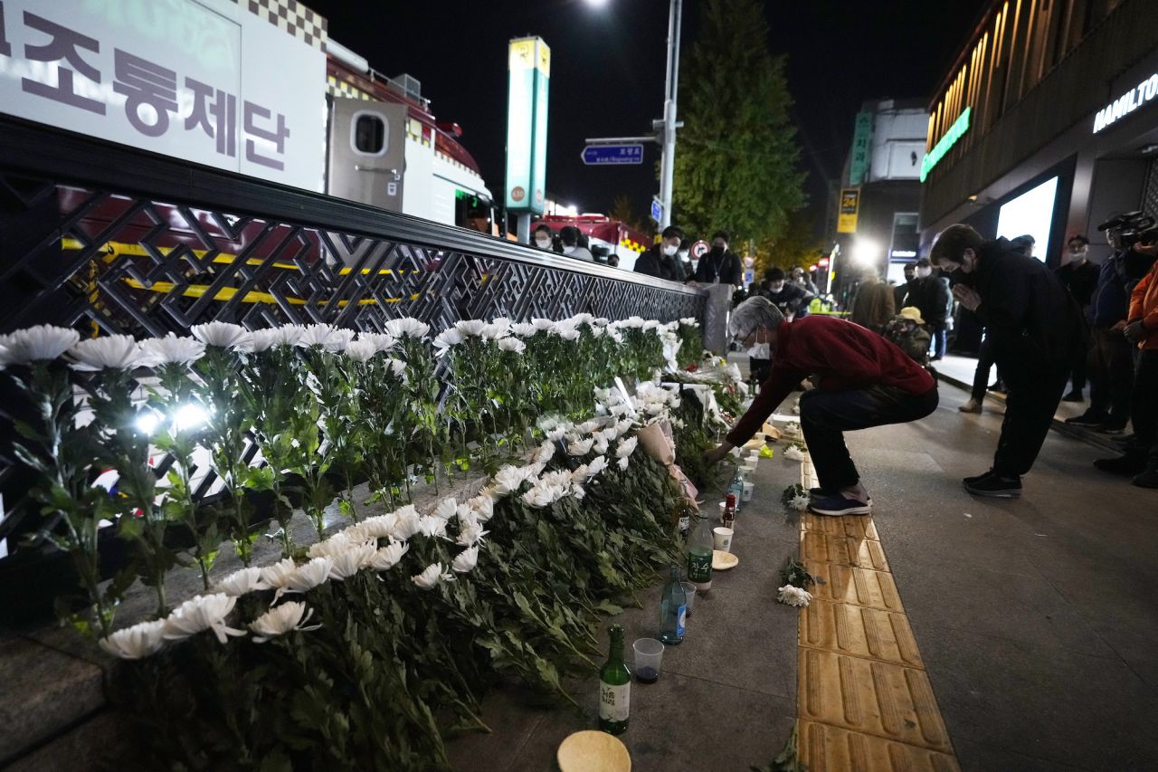 A woman places flowers to pay tribute for victims in Itaewon on Sunday night. 