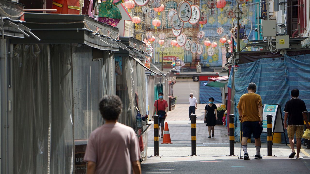 People walk past closed shops in the Chinatown district of Singapore on April 13. 