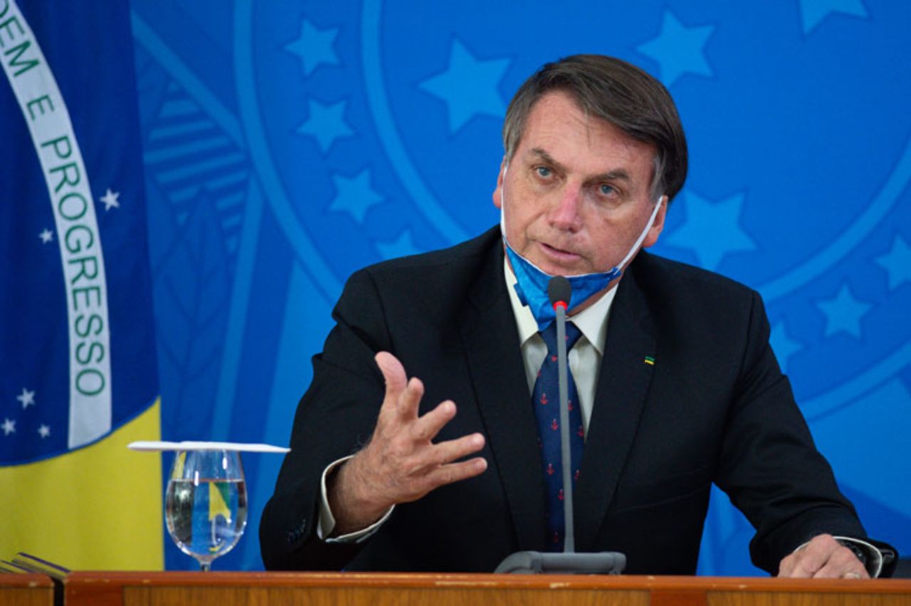 Brazilian President Jair Bolsonaro takes off his protective mask to speak to journalists during a news conference about the outbreak of the coronavirus at the Planalto Palace on March 20 in Brasilia, Brazil.