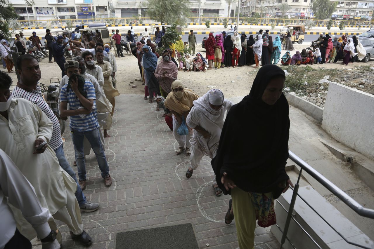 People wait to receive cash under the government's Ehsaas Emergency Cash program for families in need in Karachi, Pakistan, on April 14.