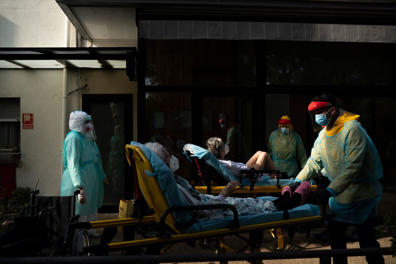 Health workers help two elderly coronavirus patients in Barcelona, Spain, on April 11.