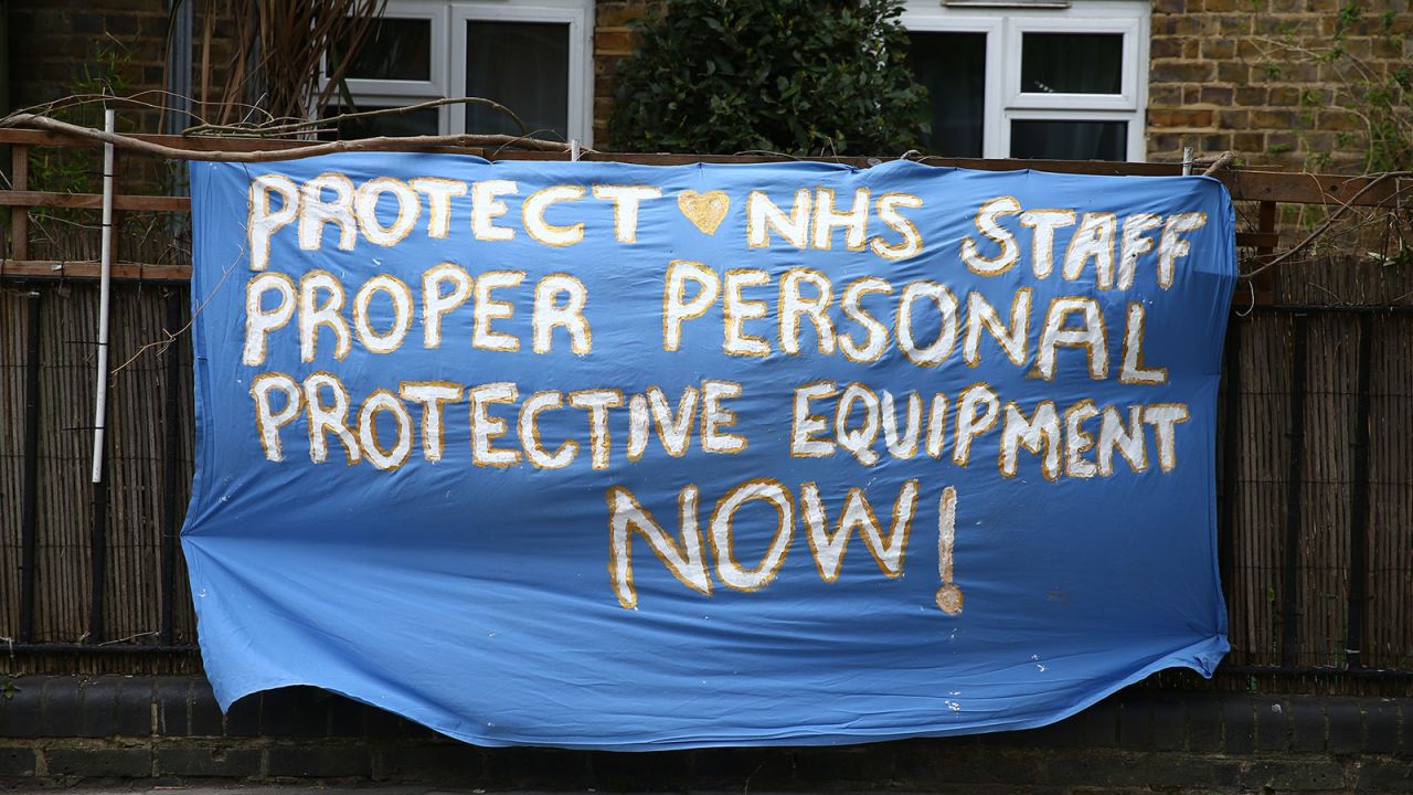 A sign calling for proper personal protective equipment for NHS staff is seen outside a home in Hackney, London on April 13.