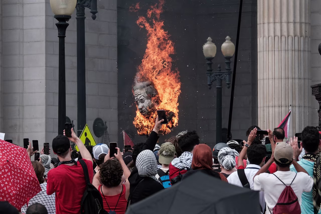 \Protestors burn a representation of Benjamin Netanyahu outside of Union Station on Wednesday, July 24