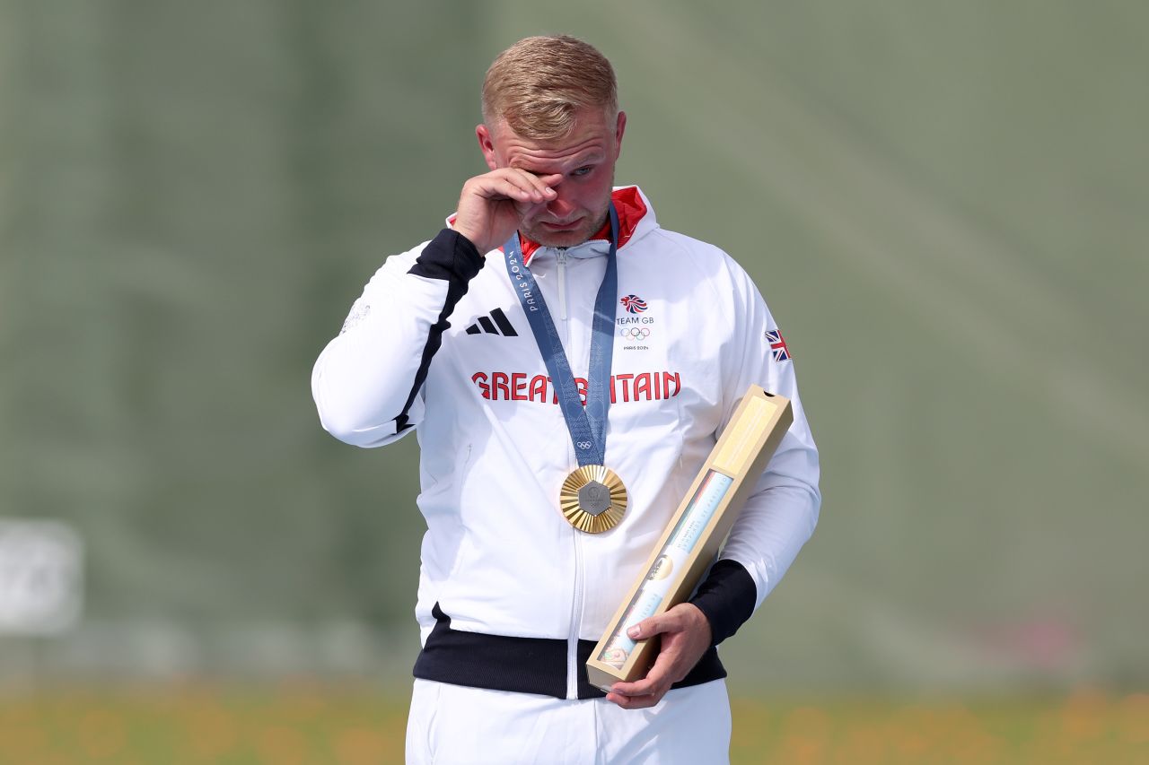 Nathan Hales of Great Britain wipes away tears on the podium after winning gold in men’s trap shooting on Tuesday.