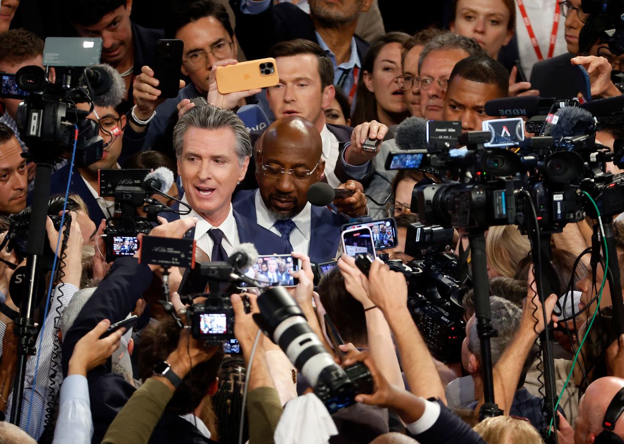 Gov. Gavin Newsom and Sen. Raphael Warnock speak to reporters in the spin room following the CNN Presidential Debate between US President Joe Biden and former President Donald Trump at the McCamish Pavilion on the Georgia Institute of Technology campus on June 27 in Atlanta. 