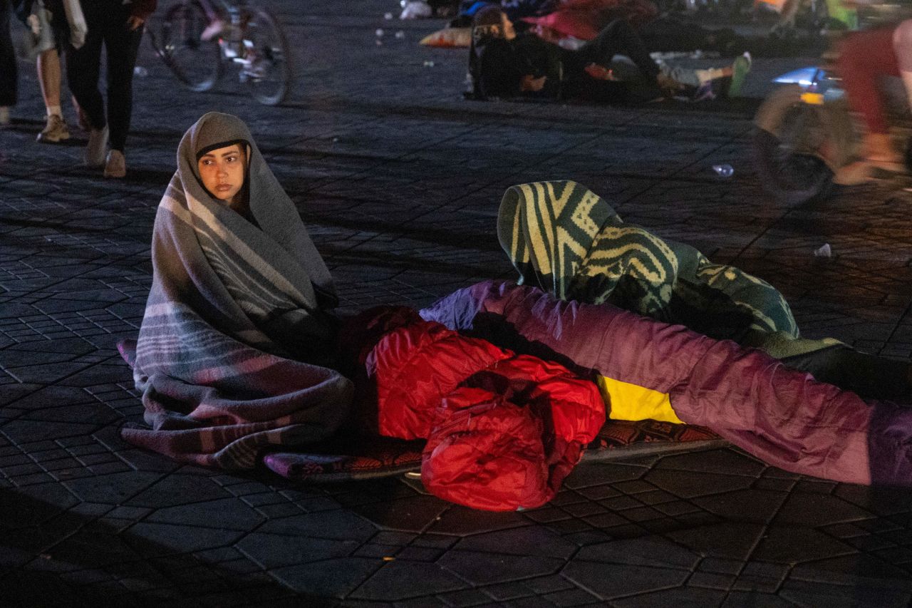 Residents take shelter outside at a square.