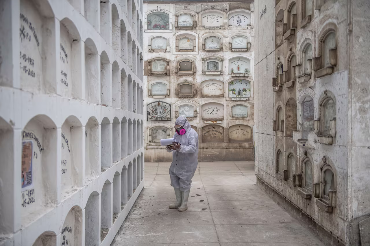 A worker checks for the names of coronavirus victims at El Angel cemetery in Lima, Peru, on May 21.