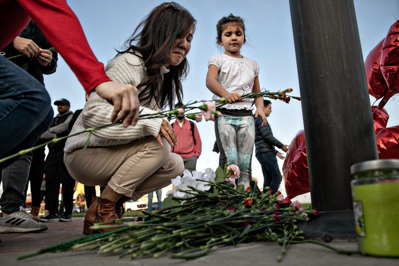  A woman places flowers at a memorial in Monterey Park, California on Sunday, January 22.