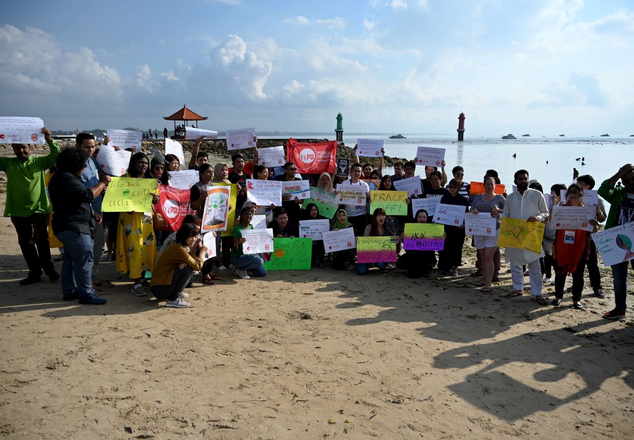 People hold a rally as part of a global climate change campaign at Sanur Beach in Bali, Indonesia.