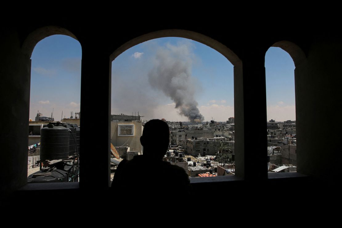 A Palestinian man watches smoke rise following Israeli strikes in the eastern part of Rafah on May 7.