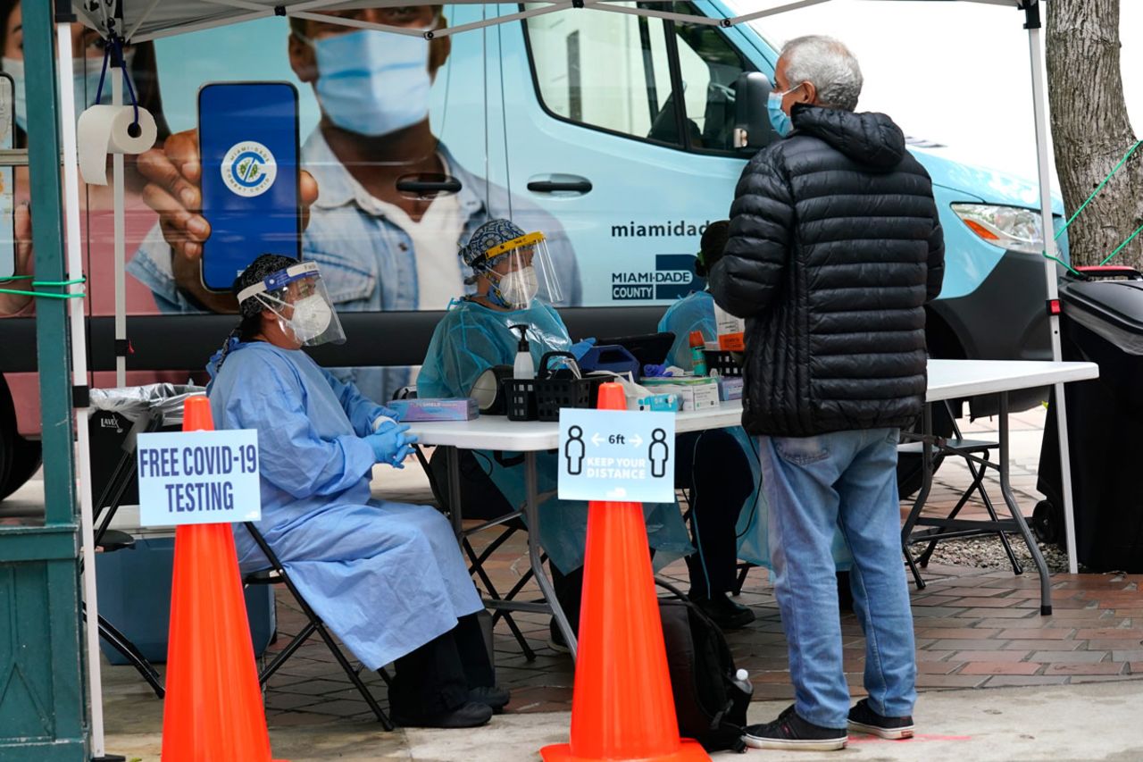 Health care workers offer free COVID-19 testing from a Miami-Dade County mobile van outside of an early voting site on Monday, October 19. in Miami.