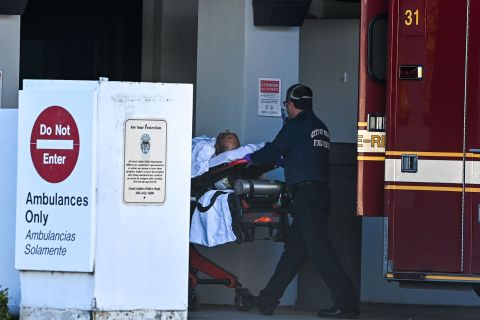 A medic transfers a patient on a stretcher from an ambulance outside of Emergency at Coral Gables Hospital where Coronavirus patients are treated in Coral Gables near Miami, Florida on December 10.