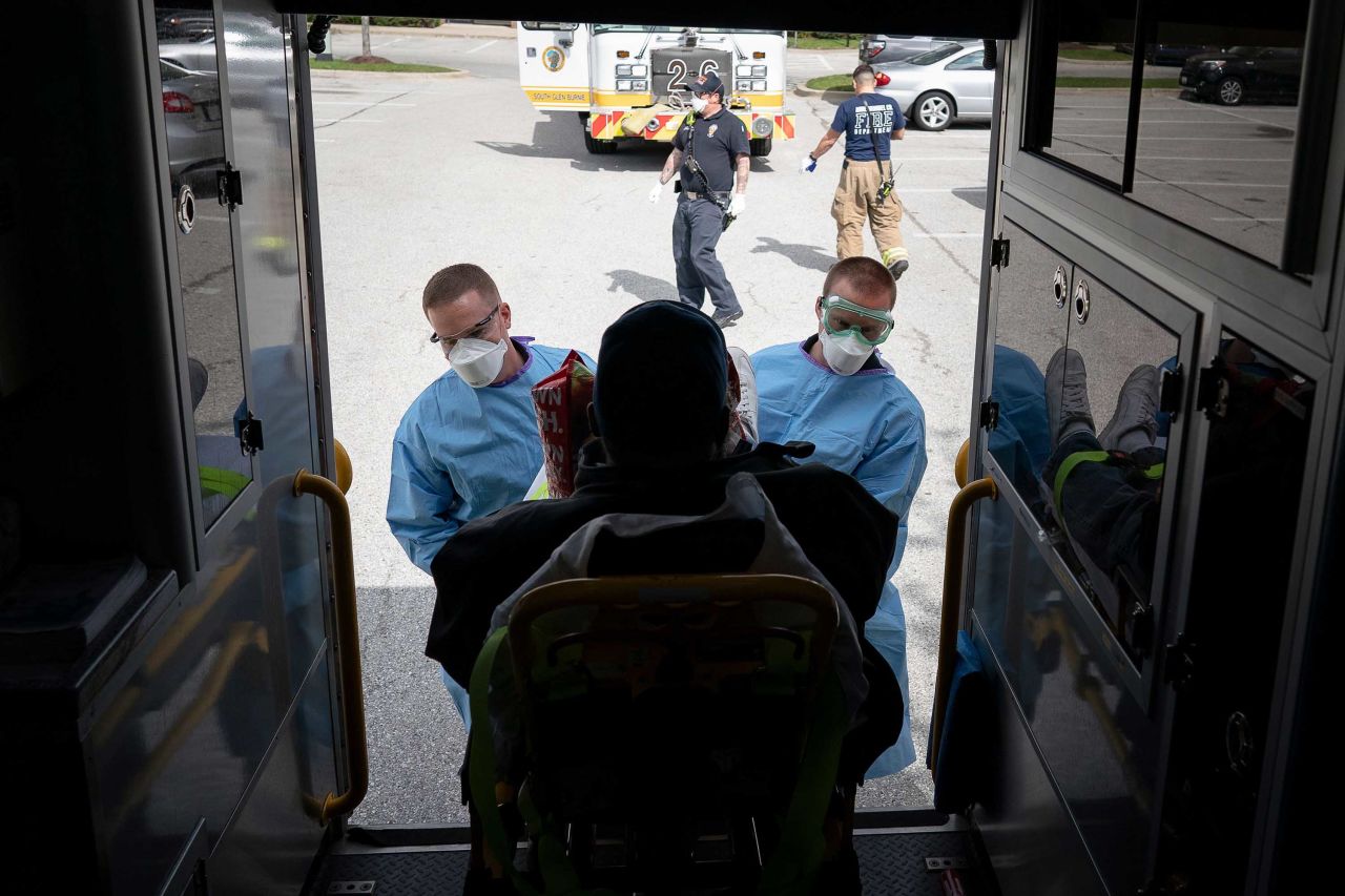 Paramedics and firefighters load a patient with coronavirus symptoms into an ambulance on April 21, in Glen Burnie, Maryland.