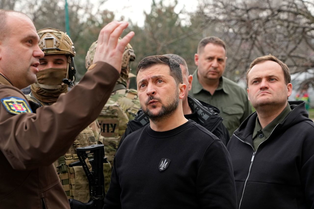 Ukraine's President Volodymyr Zelensky, center, visits a missile-damaged area of Zaporizhzhia, Ukraine, Monday March 27, 2023.