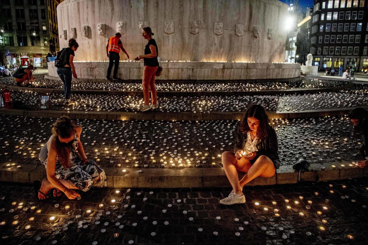 People light candles during a vigil for the victims of COVID-19 at the Dam, in Amsterdam, Netherlands, on August 6.